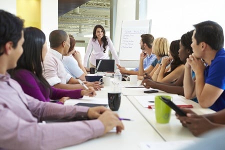 businessman addressing meeting around boardroom table