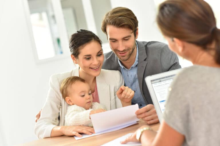 Man with wife and child reviewing documents with attorney.