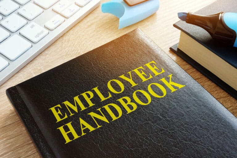 Employee handbook on a wooden desk.