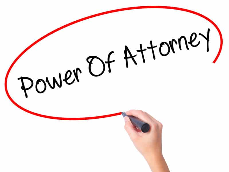 Woman's Hand writing Power Of Attorney with black marker