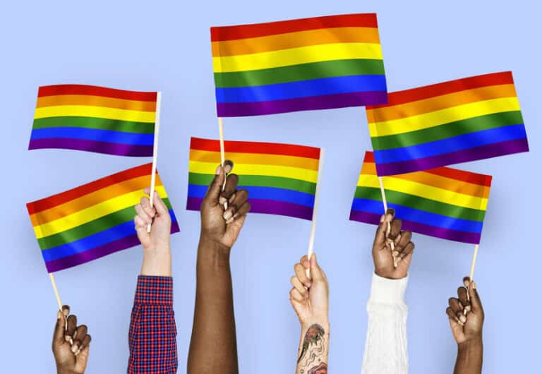 Hands waving rainbow flags