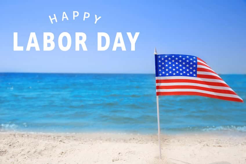 American flag on beach. Text HAPPY LABOUR DAY on background