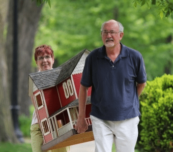 older couple carrying a suburban home in residential neighborhood, horizontal