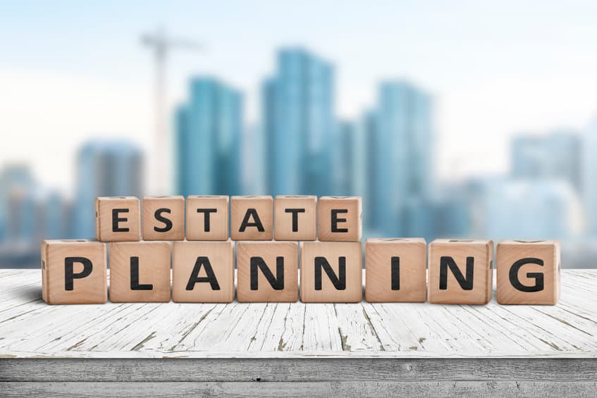 Estate planning sign on a wooden pier with tall buildings in the background