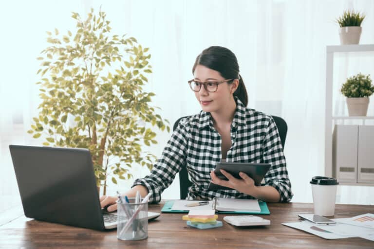 elegant beauty girl business worker holding mobile digital tablet working and connecting laptop to transport work document.